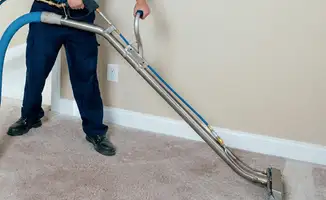 Professional operating a liquid removal machine on a carpeted floor in Tuscaloosa, AL